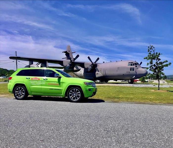 SERVPRO vehicle parked in front of a military plane